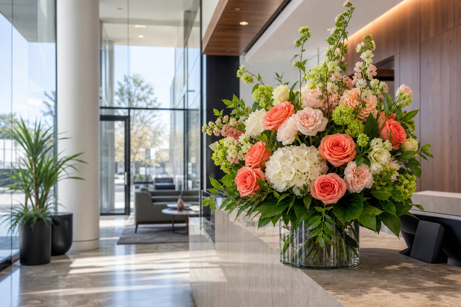 Coral and chartreuse workplace floral arrangement displayed in a modern office reception area